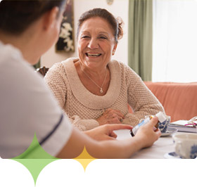 Alzheimer's caregiver and patient discuss medication while sitting at table